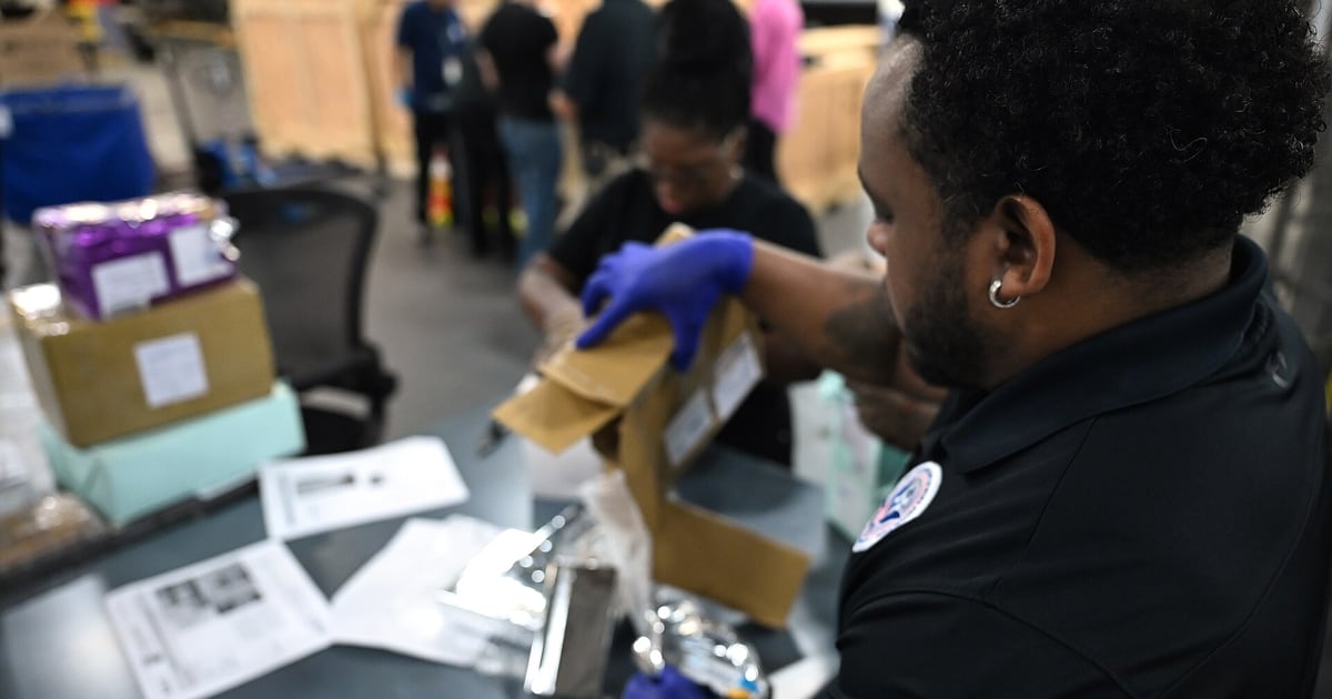 CBP officers inspecting international mail packages at the JFK International Mail Facility