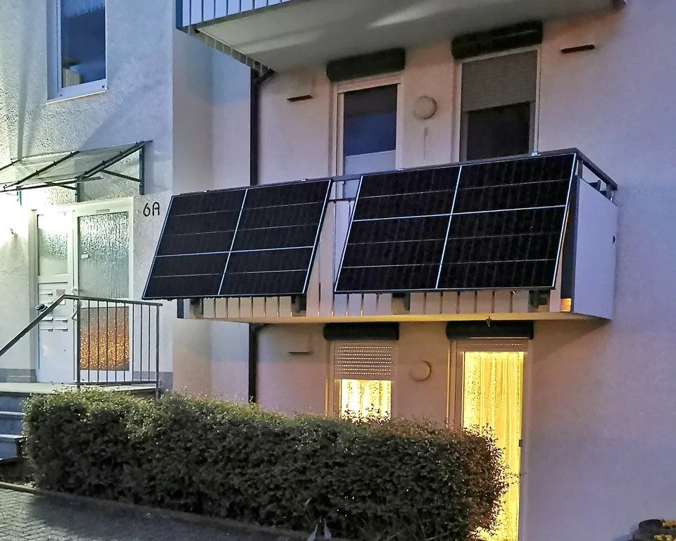 Small solar panels mounted on an apartment balcony railing